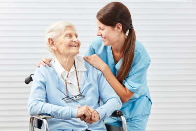 caregiver and senior smiling each other
