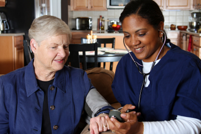 nurse checking blood pressure of a senior