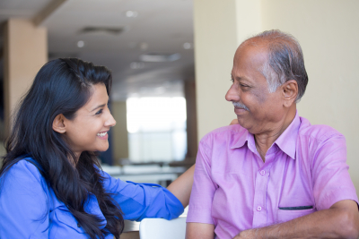 caregiver and senior smiling each other