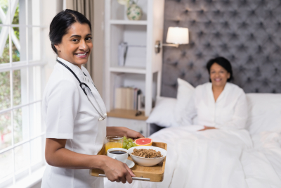 nurse serving food to a senior